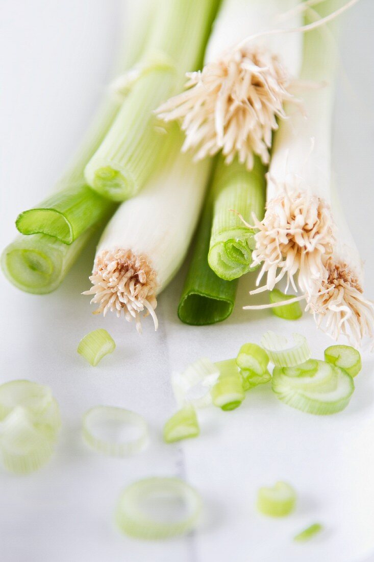 A bunch of spring onions, partially sliced
