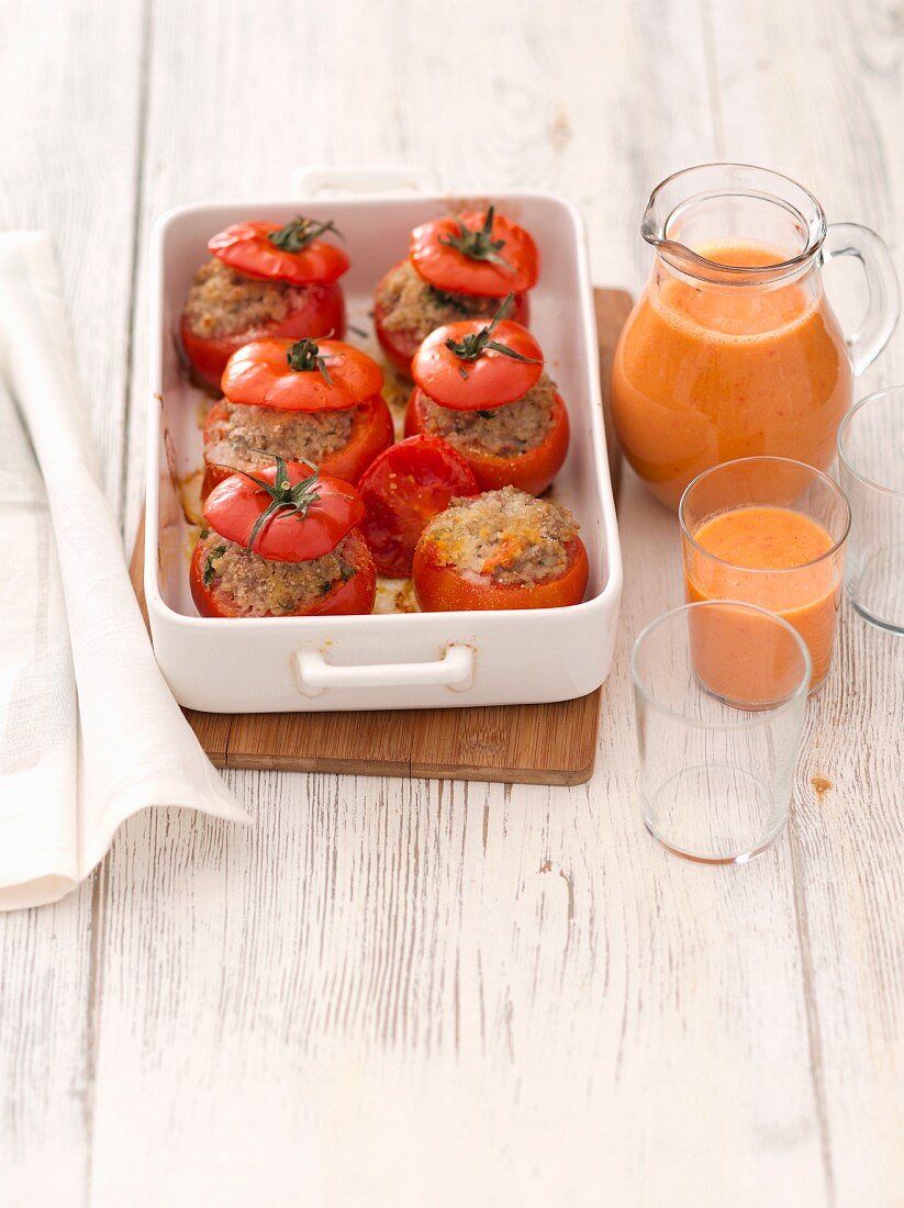 Stuffed tomatoes and gazpacho in a jug and a glass