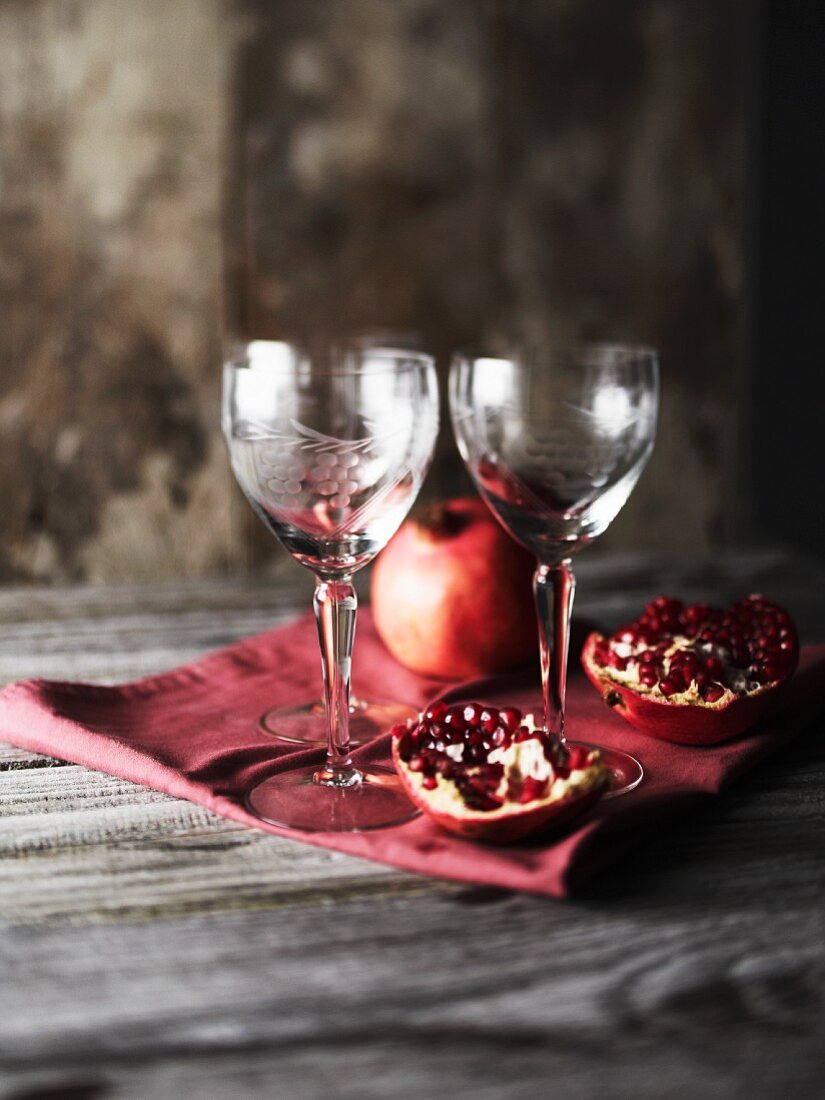 A pomegranate and wine glasses