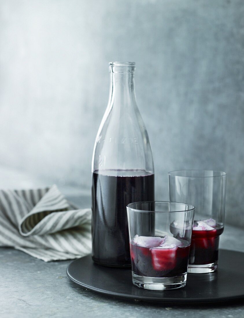Elderberry juice in glasses and a bottle
