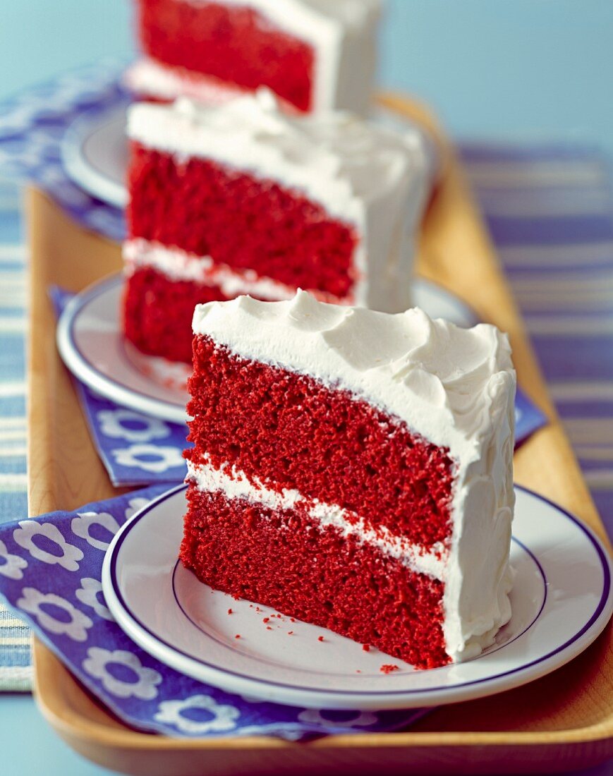 Three slices of Red Velvet cake on plates (USA)