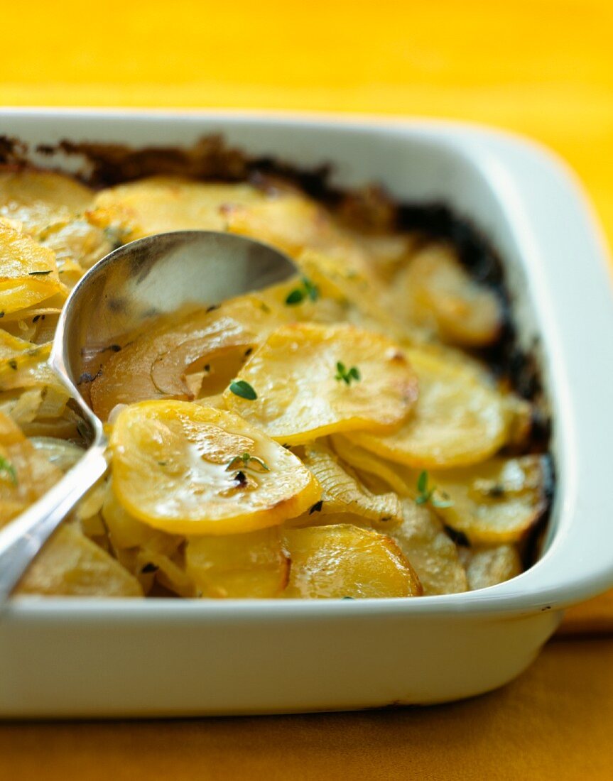 Potato gratin in a baking dish with a spoon