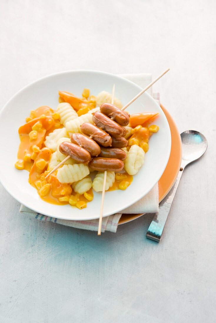 Gnocchi with carrot sauce and a sausage skewer