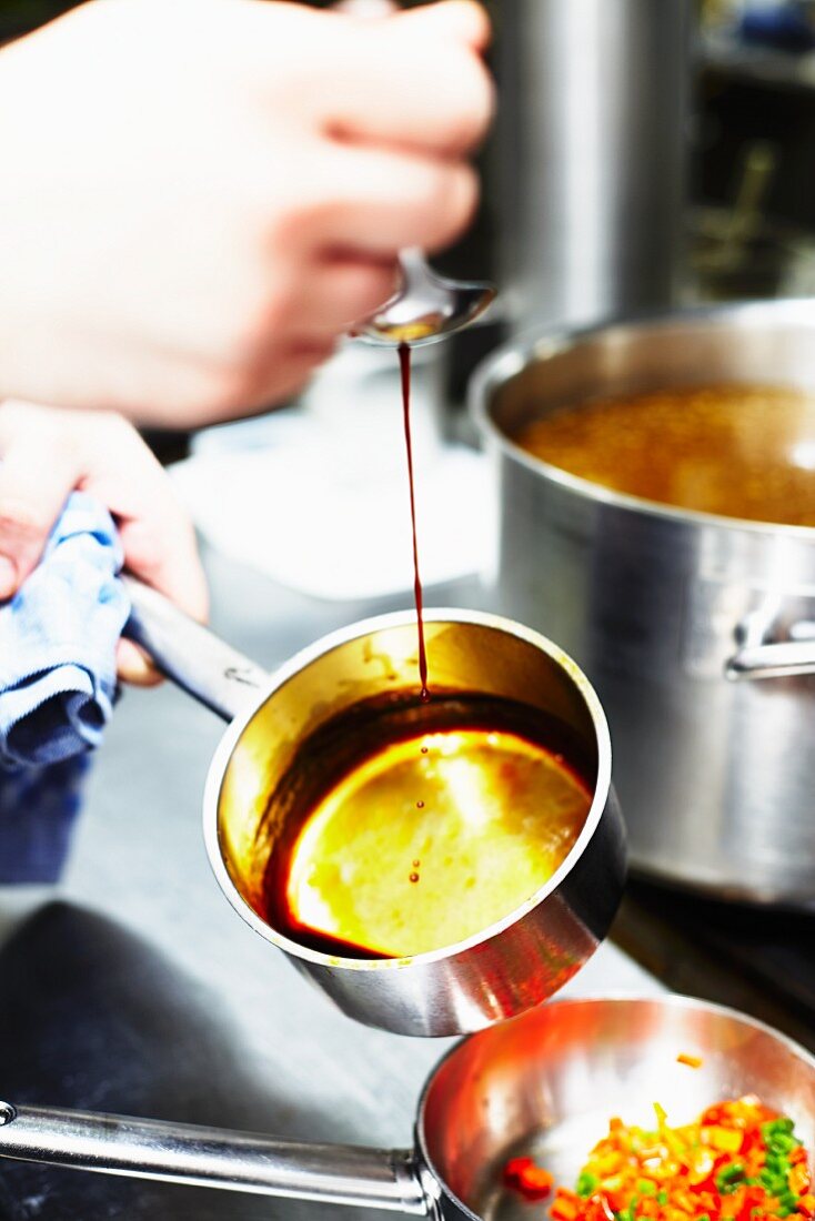 A chef caramelising sugar in a pot