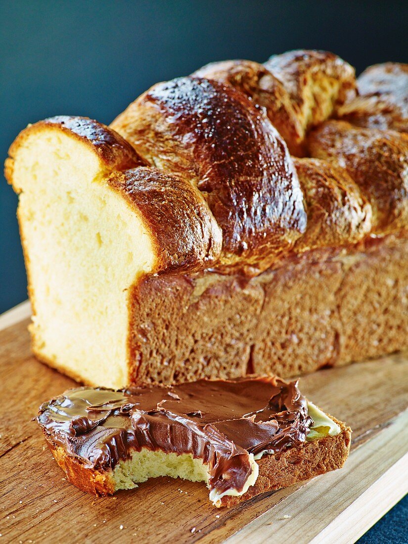 A loaf of plaited bread with a slice cut off