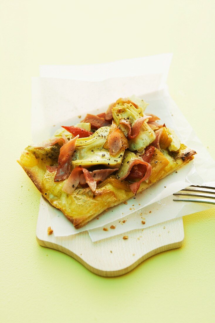 A pizza topped with artichokes and ham