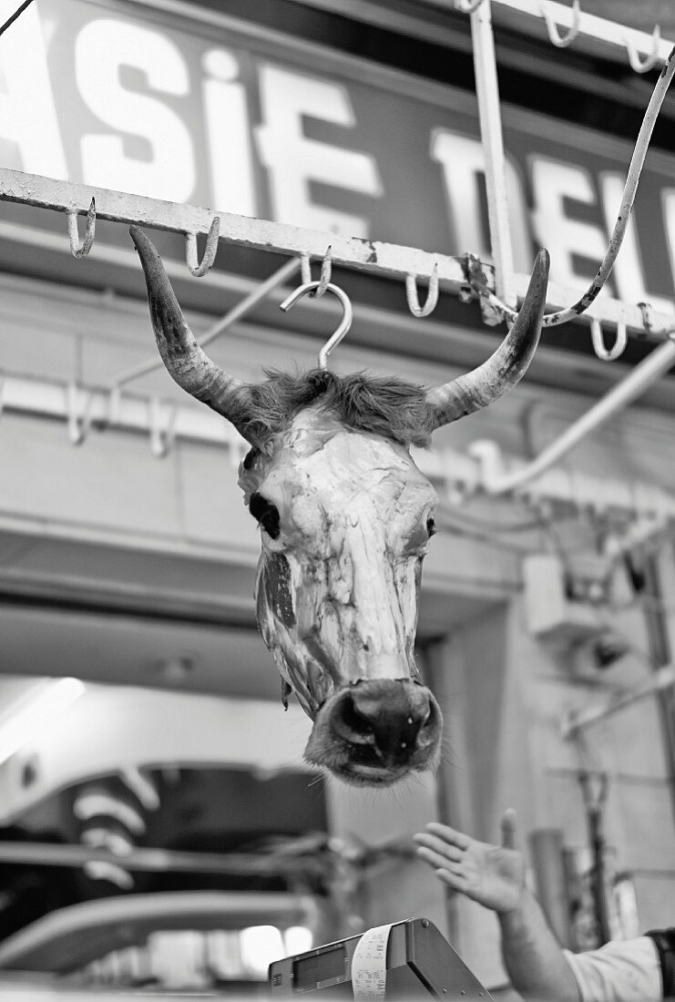 A cow's head hanging in a butcher's