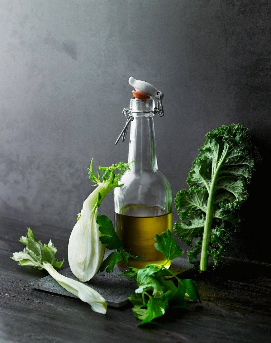 An arrangement of olive oil, vegetables and herbs