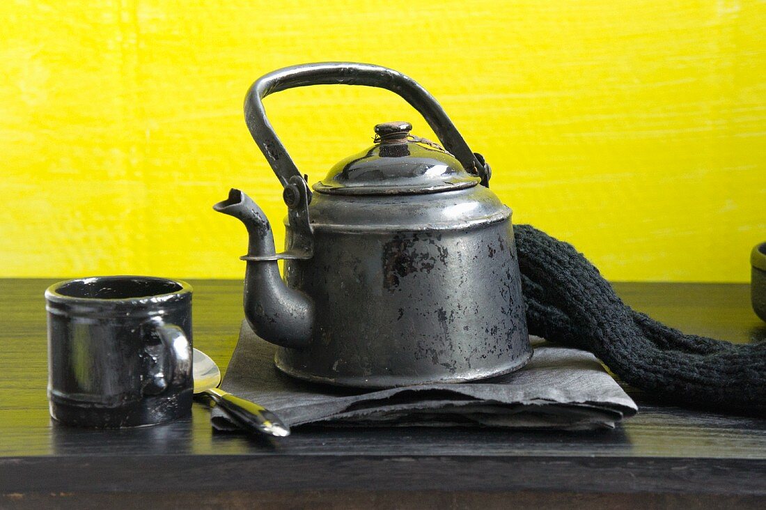 An old coffee pot and a coffee cup