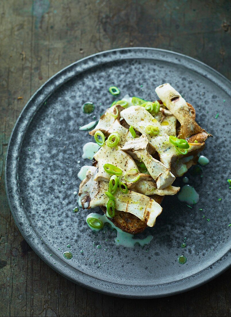 Fried porcini mushrooms with spring onions on grilled bread