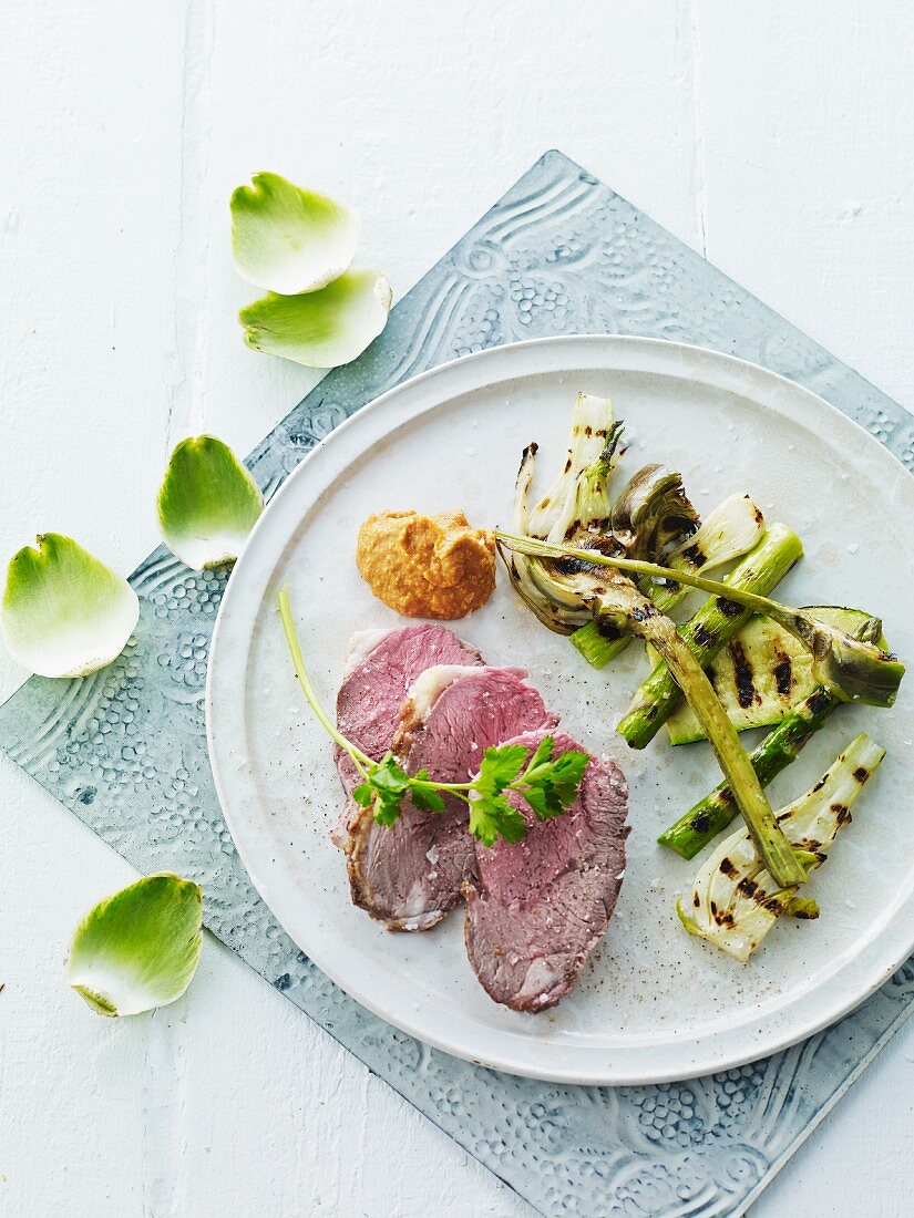 Roast lamb with grilled artichokes, courgettes and asparagus