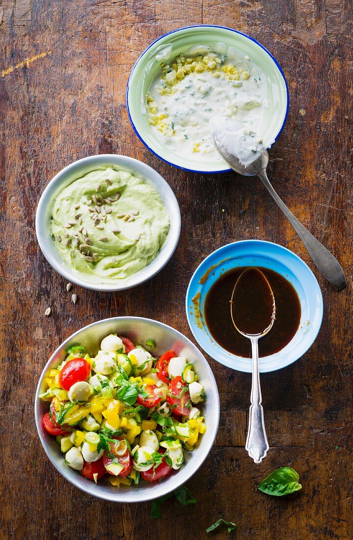 A colourful salad, a chive an dlemon dip, teriyaki sauce and avocado cream