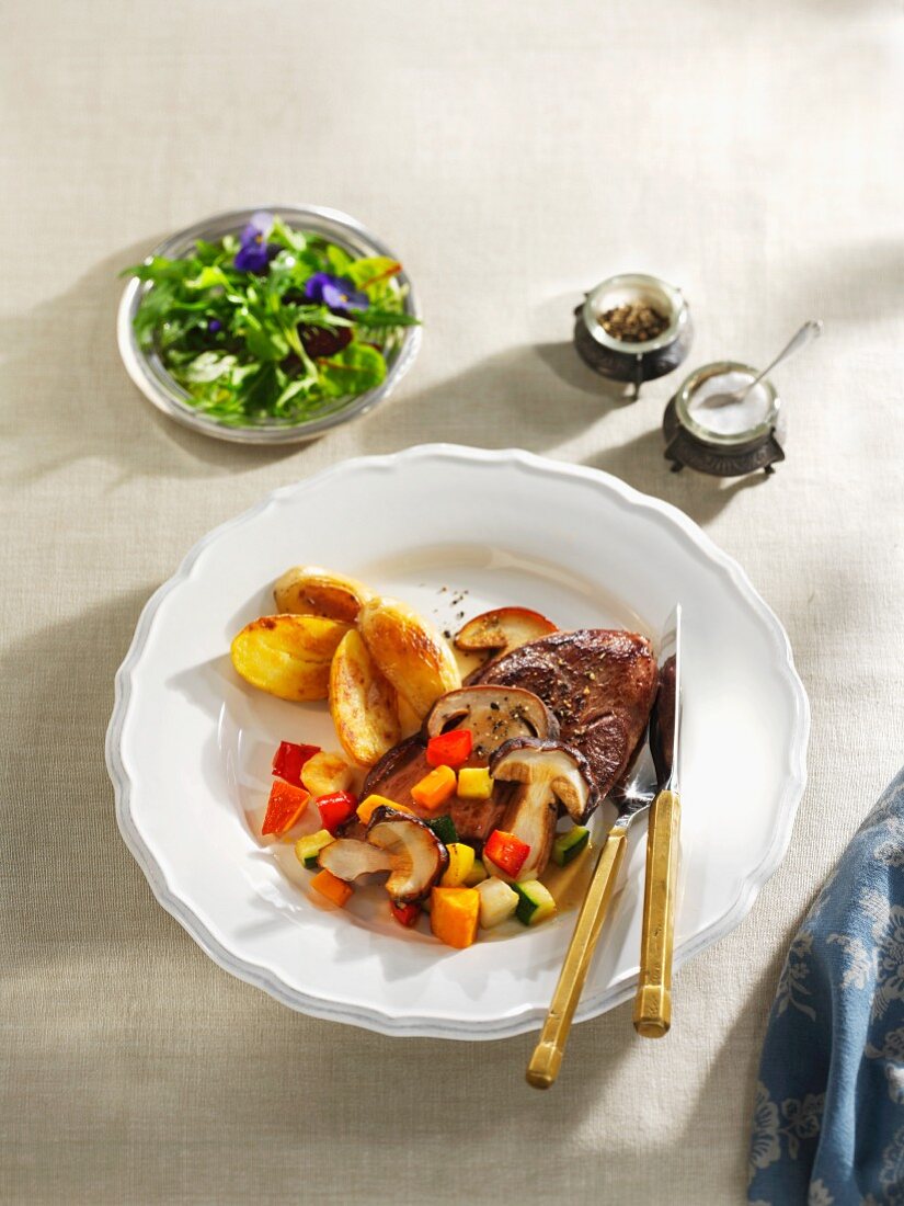 Venison escalope on a bed of colourful vegetables