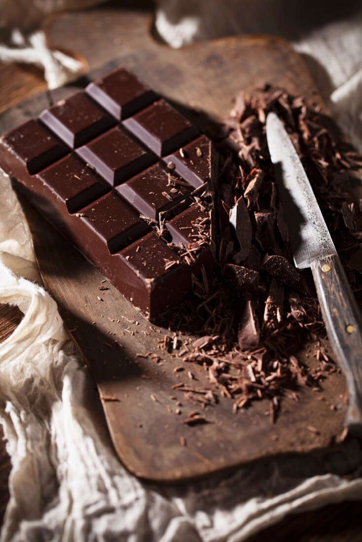 Zerkleinerte dunkle Schokolade auf Holzbrett