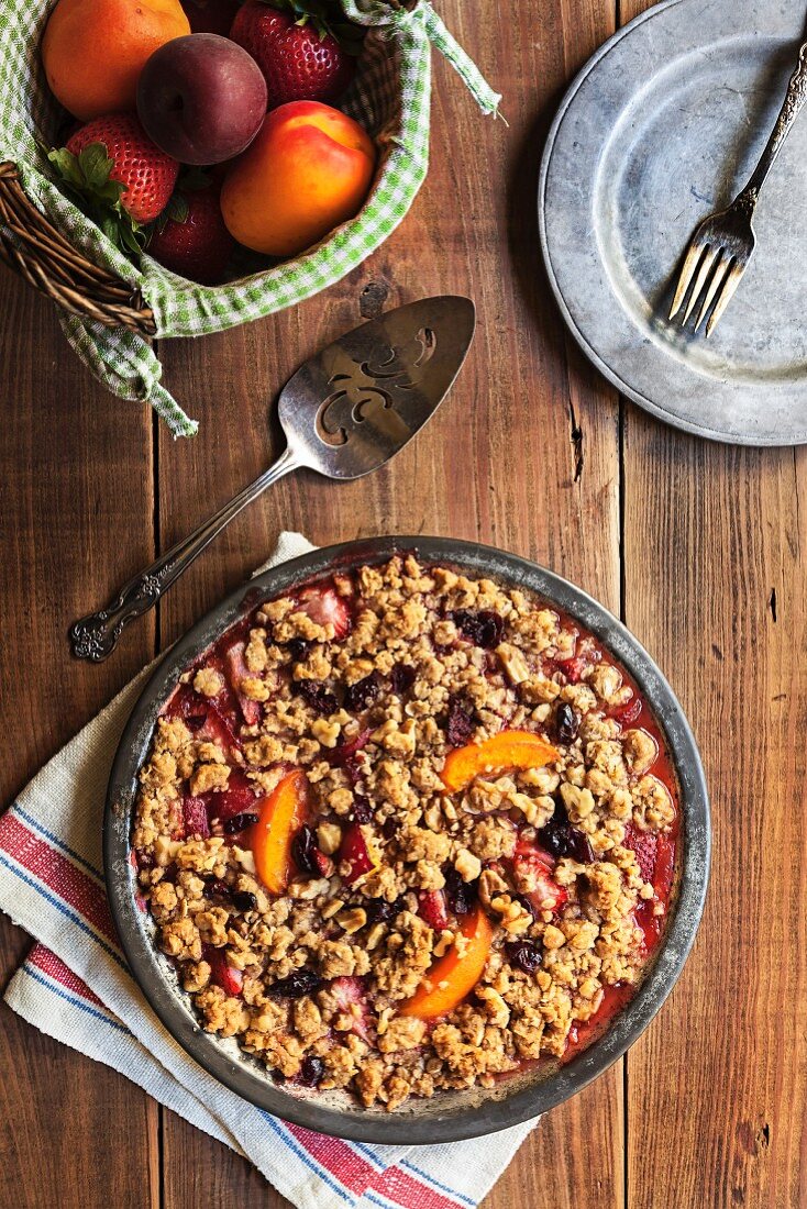 Freshly baked walnut crumble with strawberries, apricots and cranberries