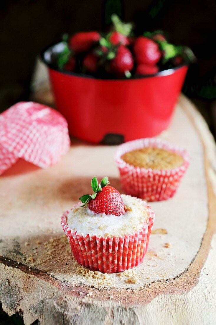 Cheesecake cupcakes with icing sugar and strawberries