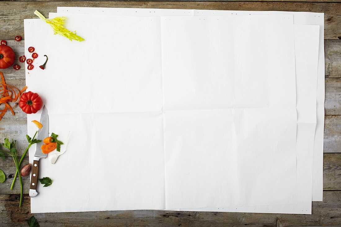 Gemüsestillleben am Bildrand von weißem Papier