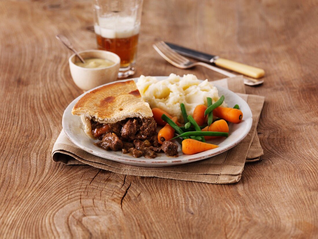 Steak and ale pie with mashed potatoes and vegetables (England)