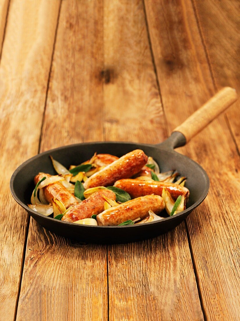 Cumberland Sausages mit Salbei und Zwiebeln in Bratpfanne (England)