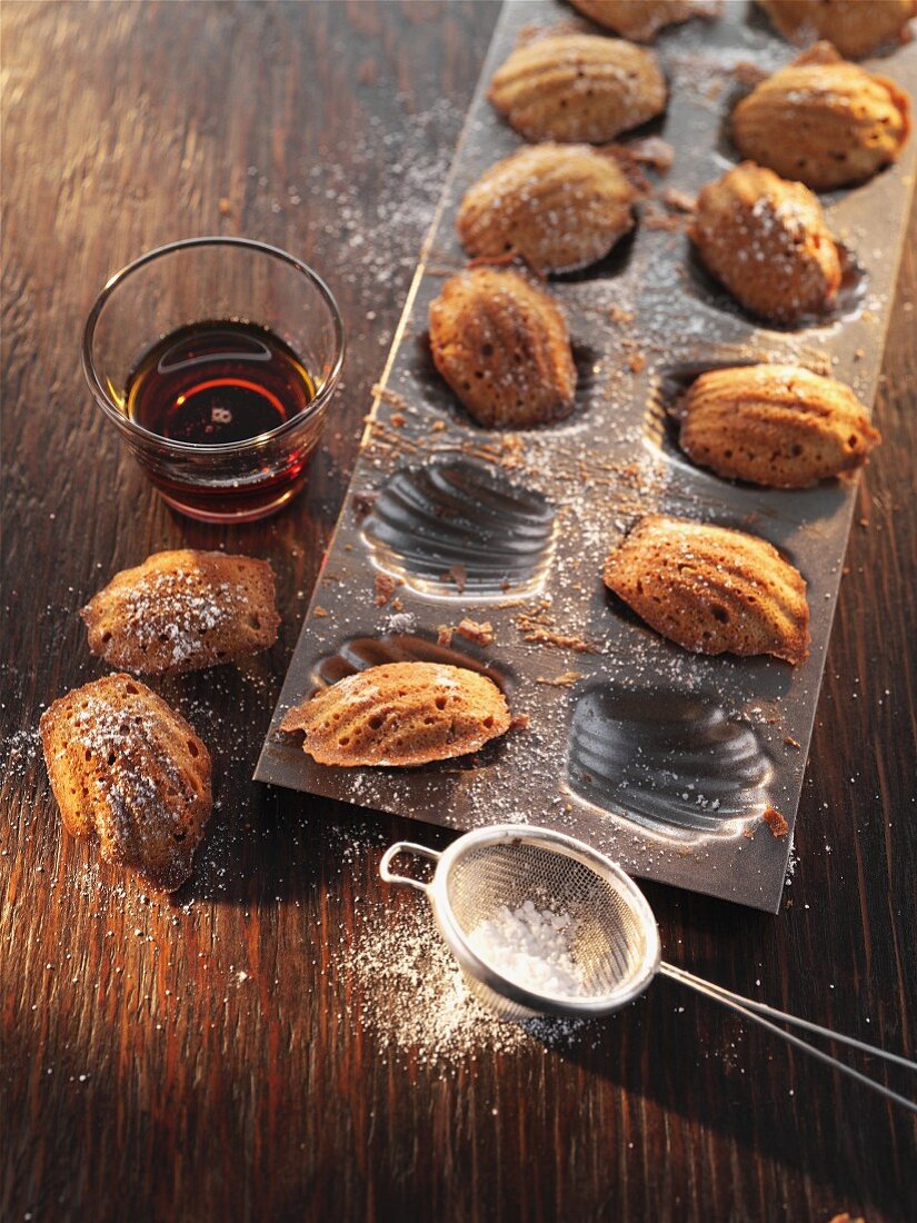 Madeleines with icing sugar in a baking tin