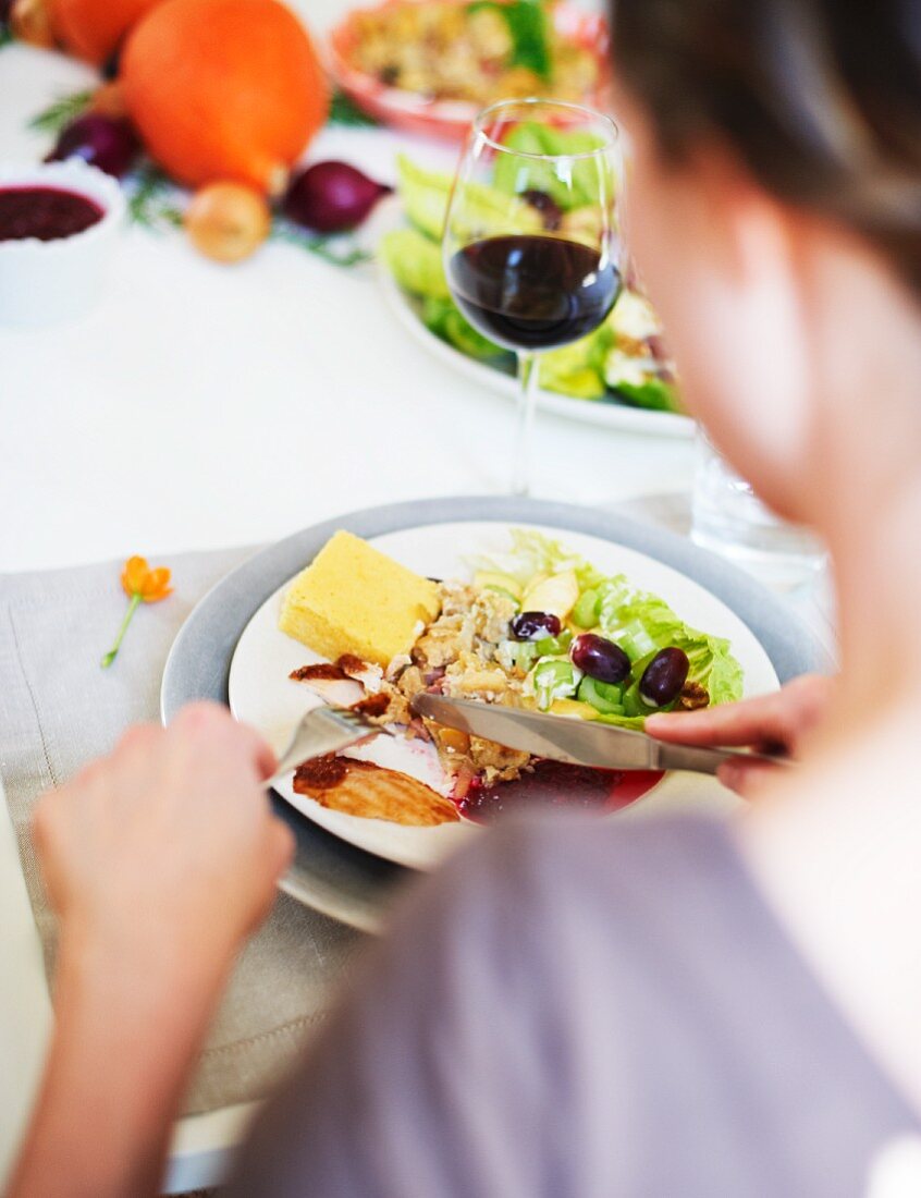 Frau isst Waldorfsalat mit Maisbrot zu Thanksgiving