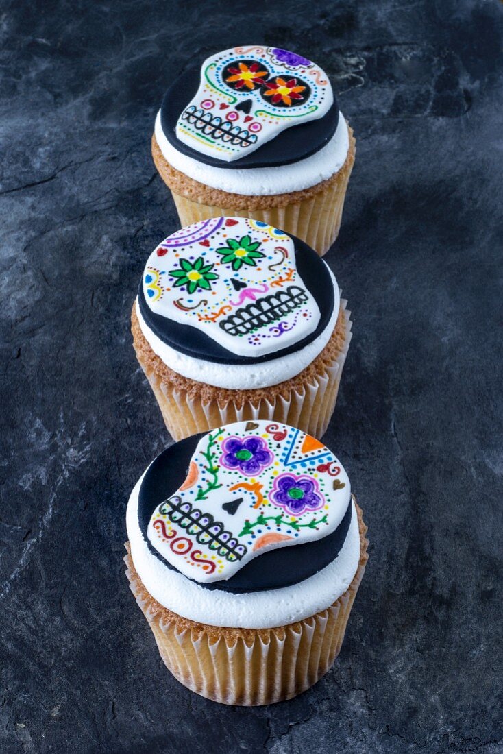 Three cupcakes decorated with skulls for Halloween