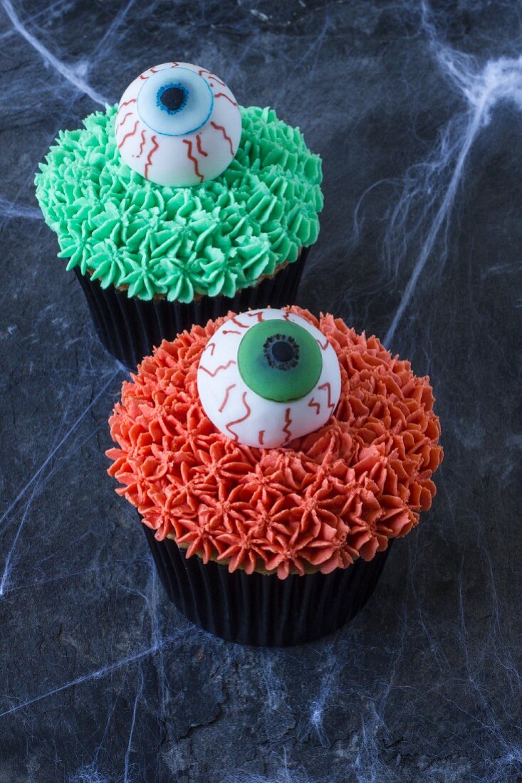 Two cupcakes decorated with sugar eyes for Halloween