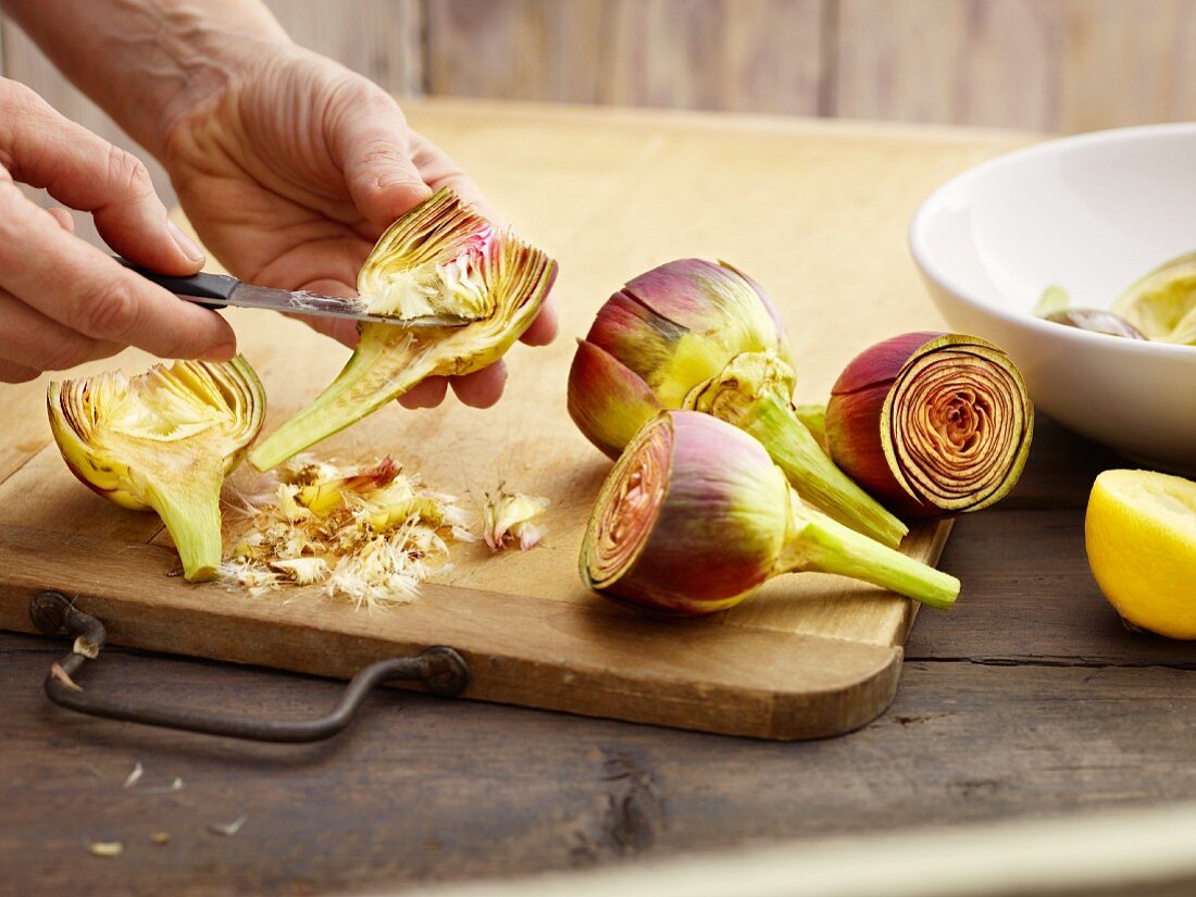 Artichokes being prepared: choke being removed