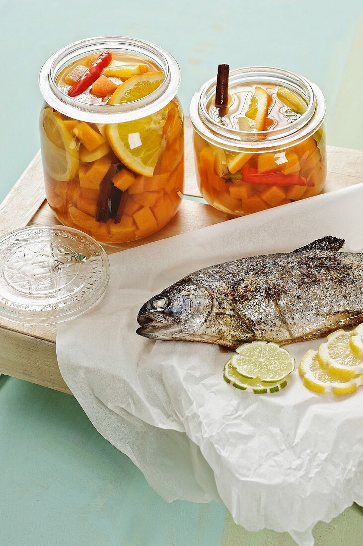 Two jars of sweet and sour pickled pumpkin with grilled trout