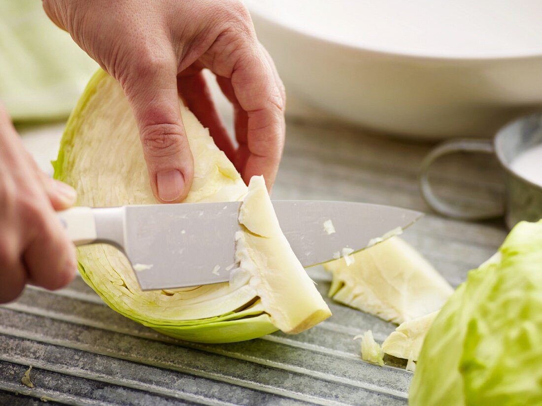 White cabbage being prepared: stem being removed