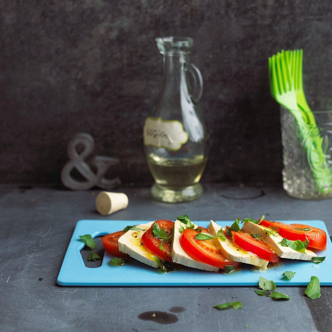 Caprese mit Tofu auf blauem Schneidebrett