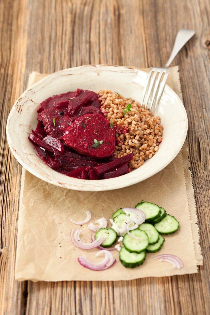 Steak braised in beetroot with buckwheat, and a cucumber and onion salad