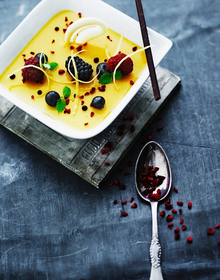 Crème brûlée garnished with fresh berries and barberries