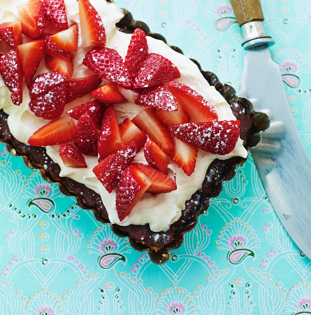 Kuchen mit Schokoladenglasur, Vanillesahne und Erdbeeren