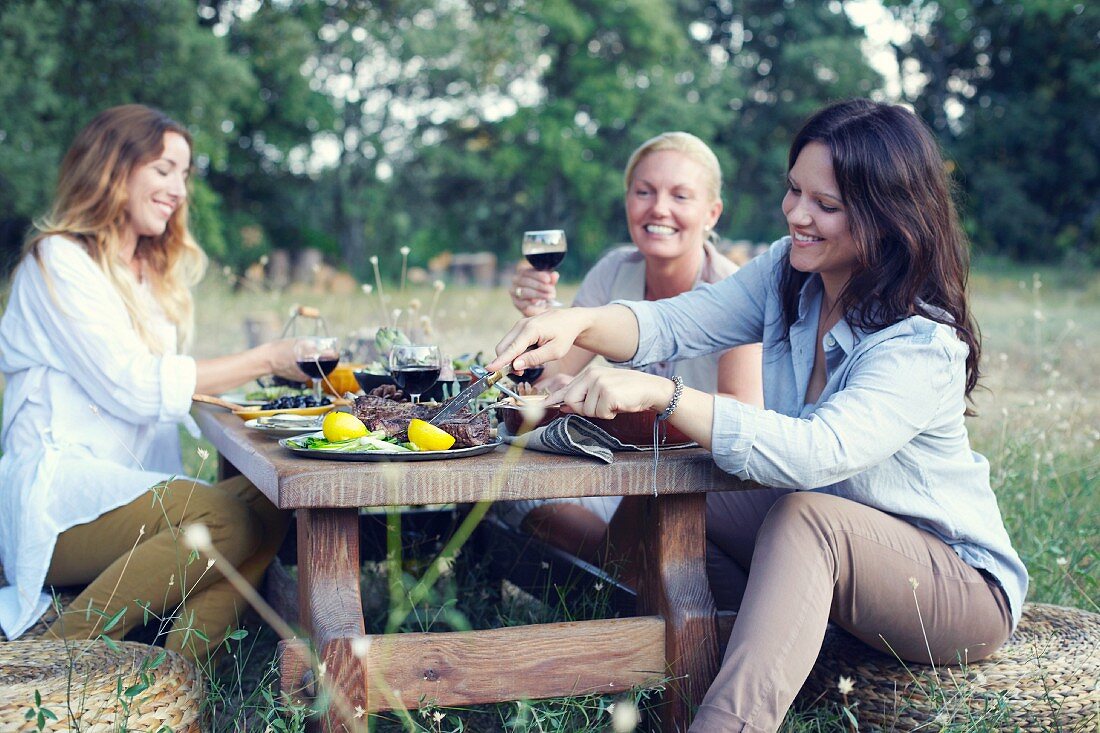 Drei Frauen beim provenzalischen Essen im Garten