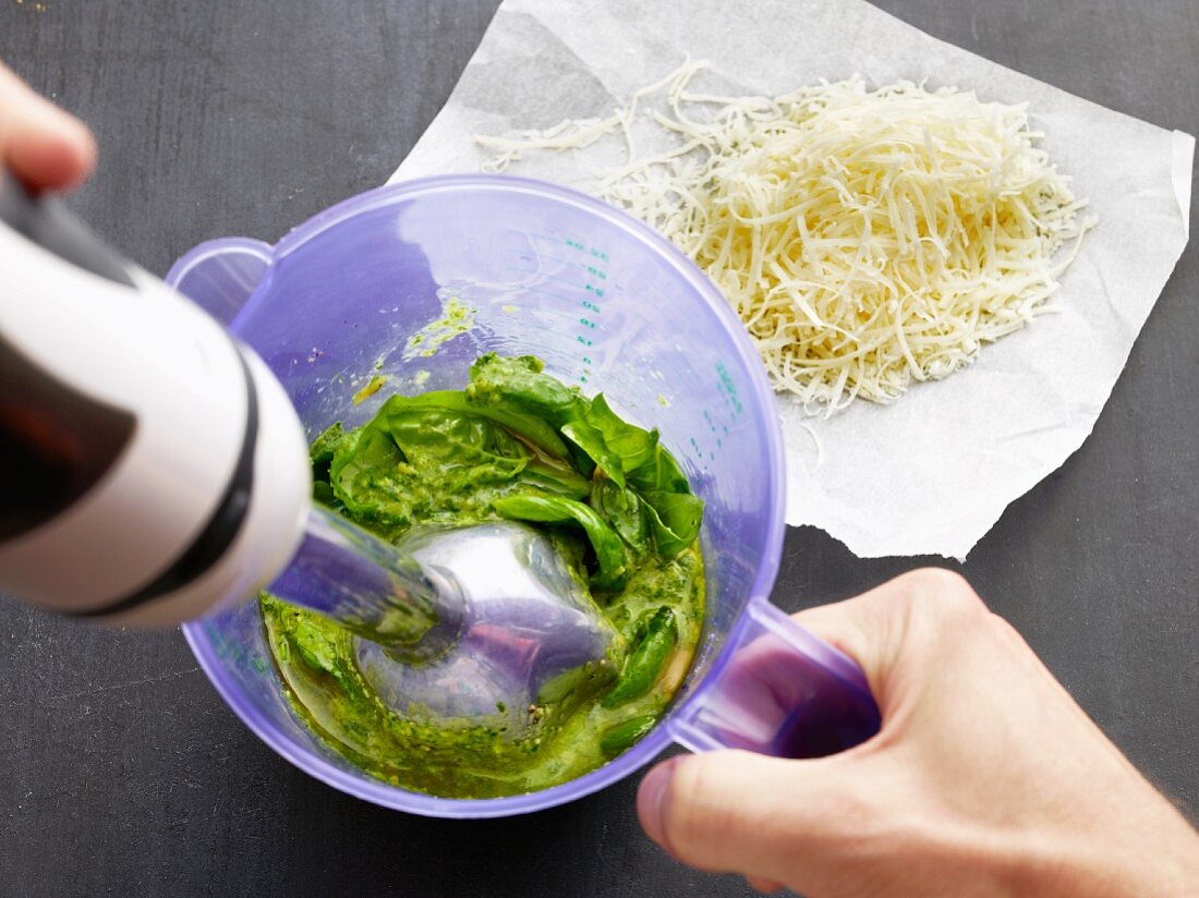 Basil being puréed with a hand mixer