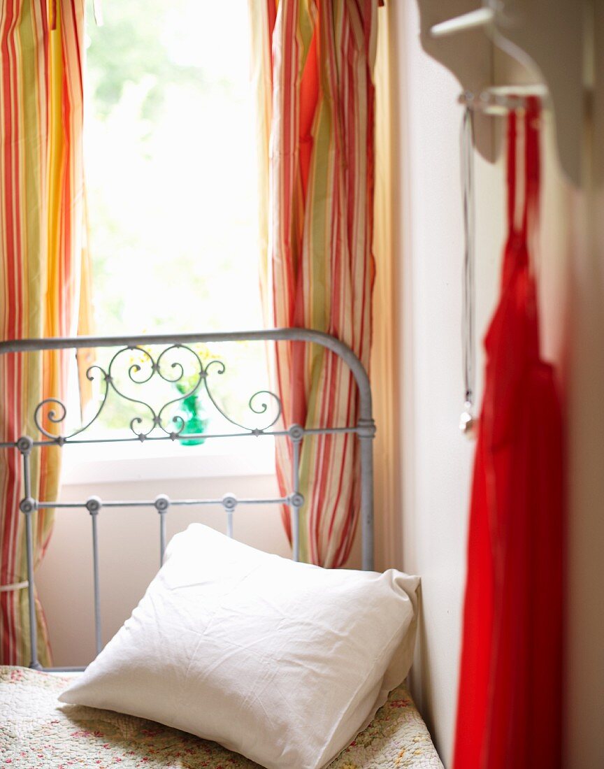 Scatter cushion on romantic metal bed below window