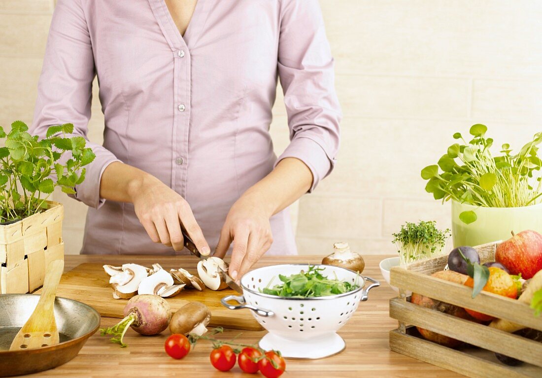 Fresh fruit and vegetables and a woman slicing mushrooms