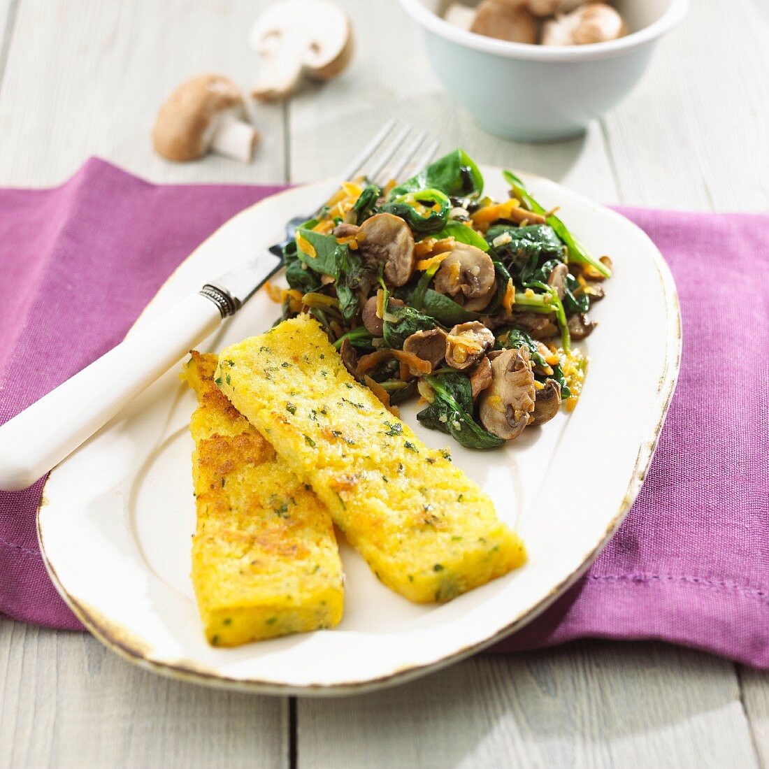Polenta slices with spinach and mushrooms