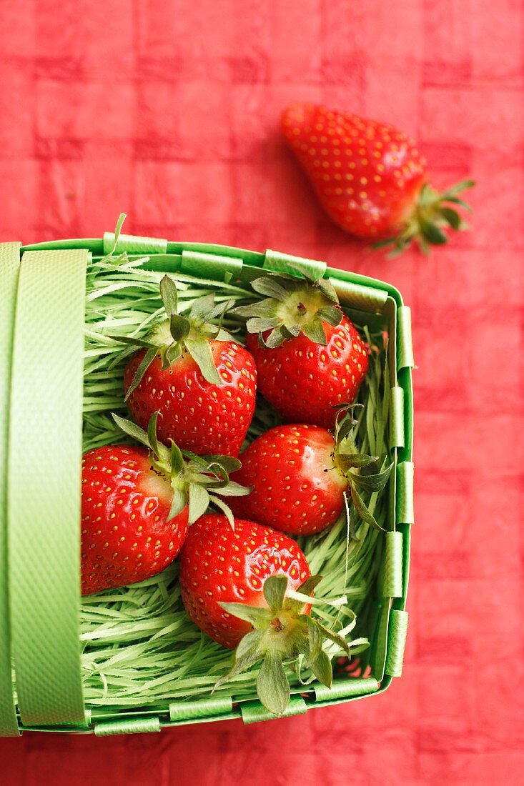 Fresh strawberries in a green plastic basket