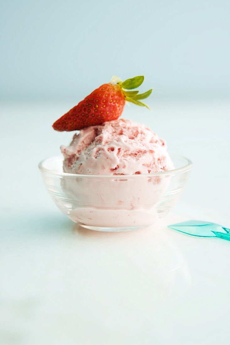 A scoop of strawberry ice cream in a bowl
