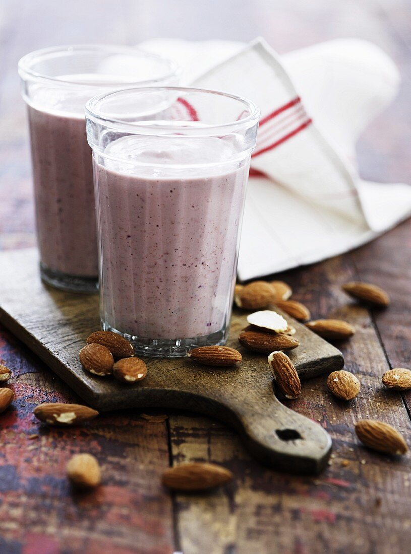 Berry smoothies made with almonds on a wooden board