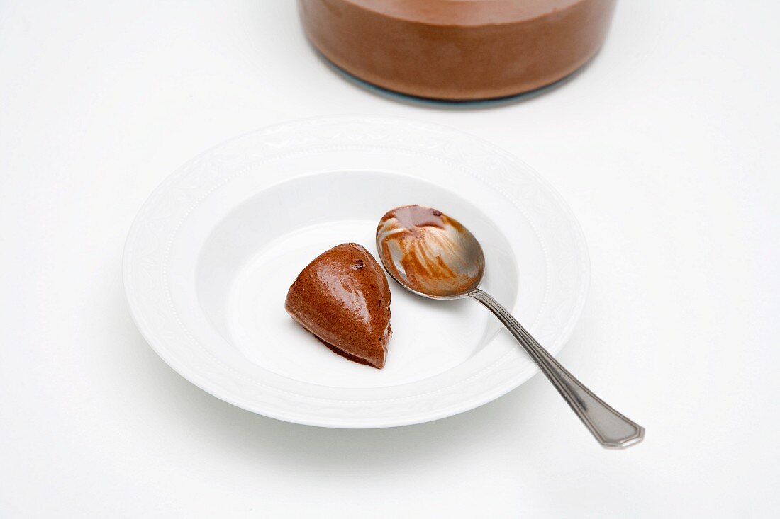 Chocolate cream dumpling with a spoon on a white plate