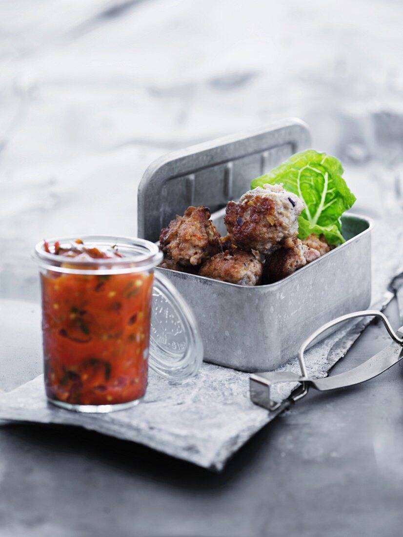 Chilly meatballs in a picnic tin with a dipping salsa