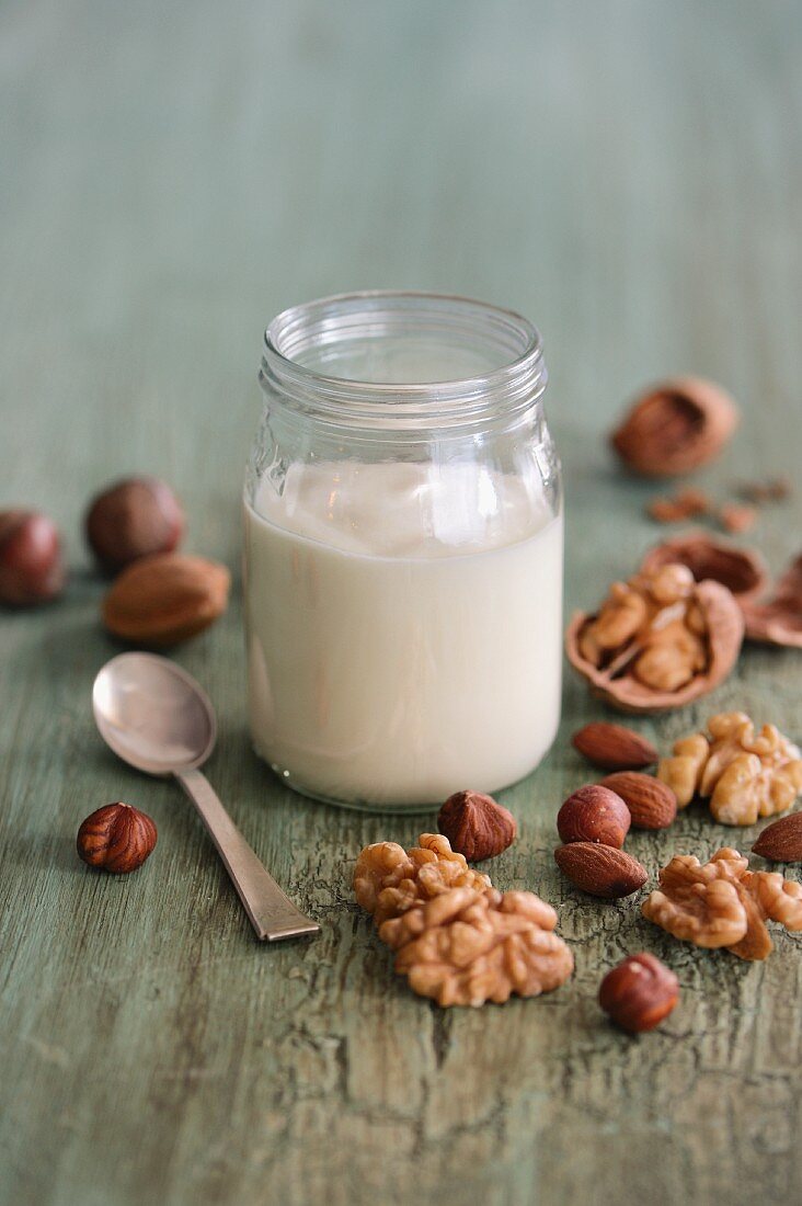 An arrangement featuring a jar of yogurt and various nuts