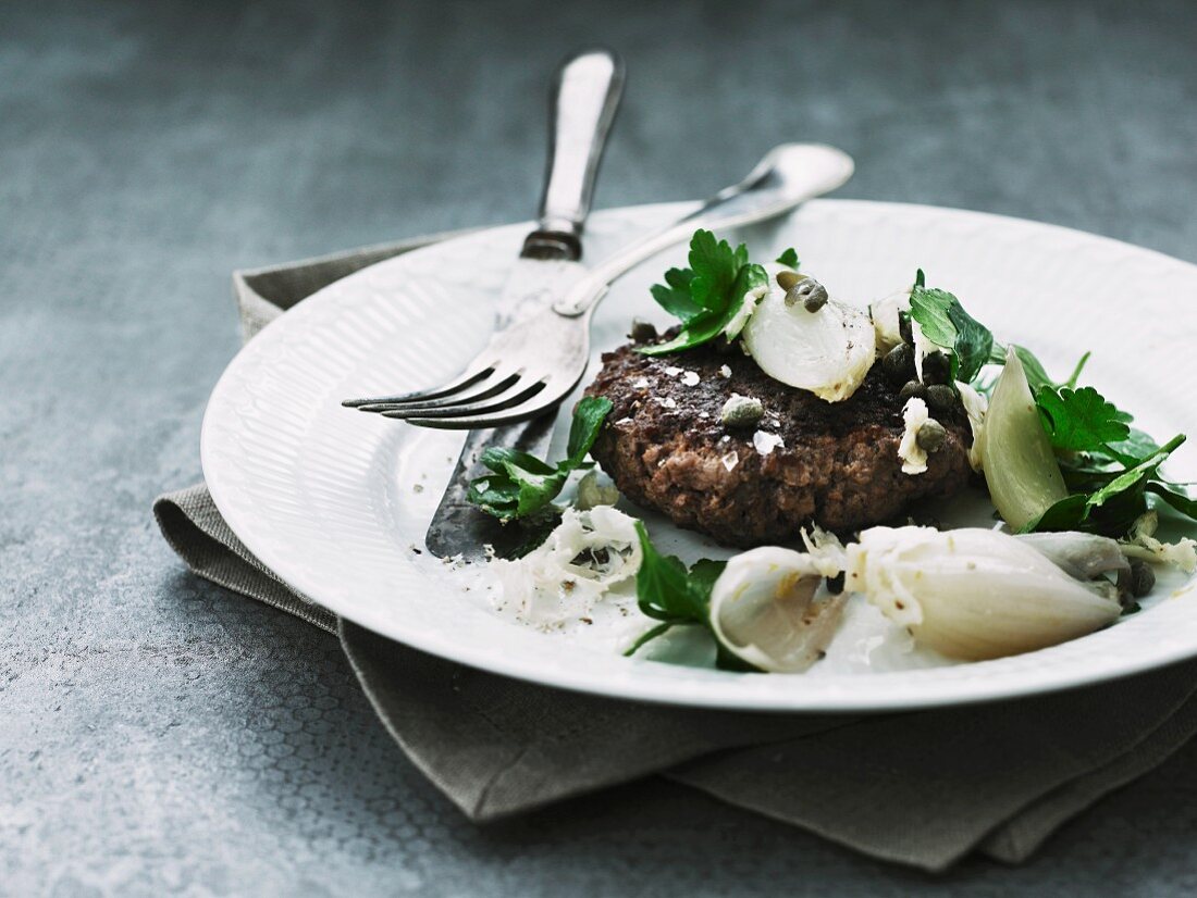 A venison burger with shallots, horseradish, capers and parsley