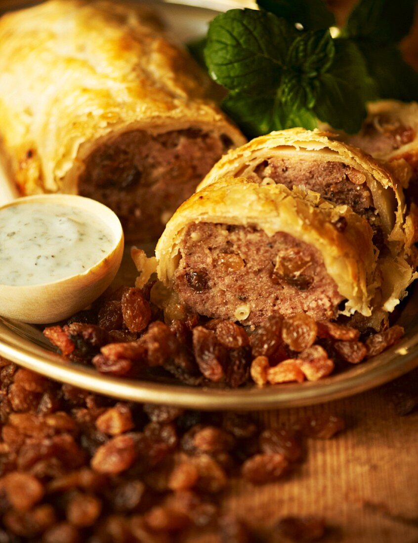 Minced meat in puff pastry with raisins and mint yoghurt