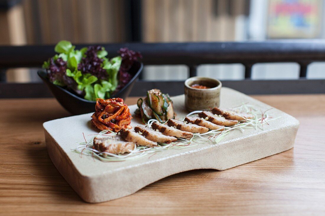 Korean-style chicken breast fillet with accompaniments and salad