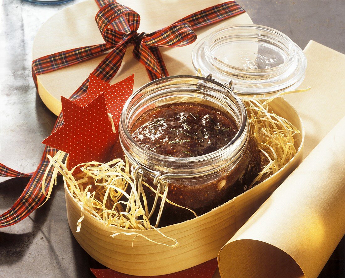 Ein Glas Feigen-Johannisbeer-Marmelade im Geschenkkarton