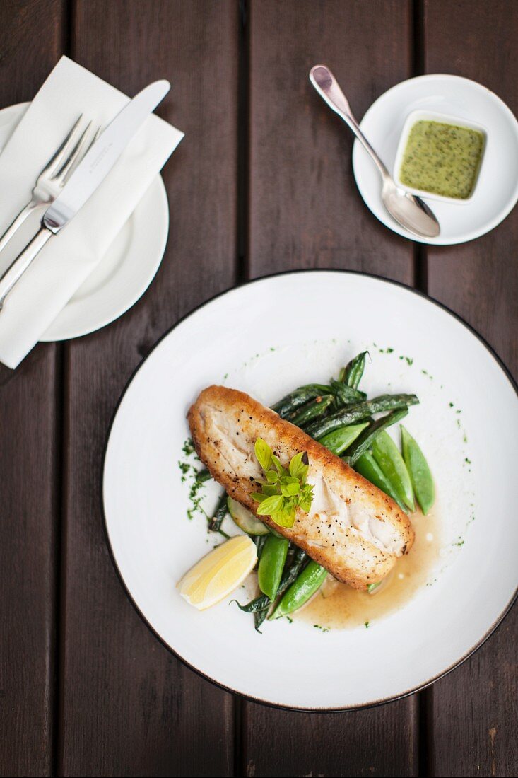 Hake on a bed of green vegetables